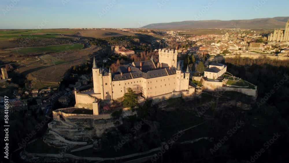 Aerial tilt down view of medieval Alcazar of Segovia castle on hilltop at sunset time Aerial tilt down view of medieval Alcazar of Segovia castle on hilltop at sunset time