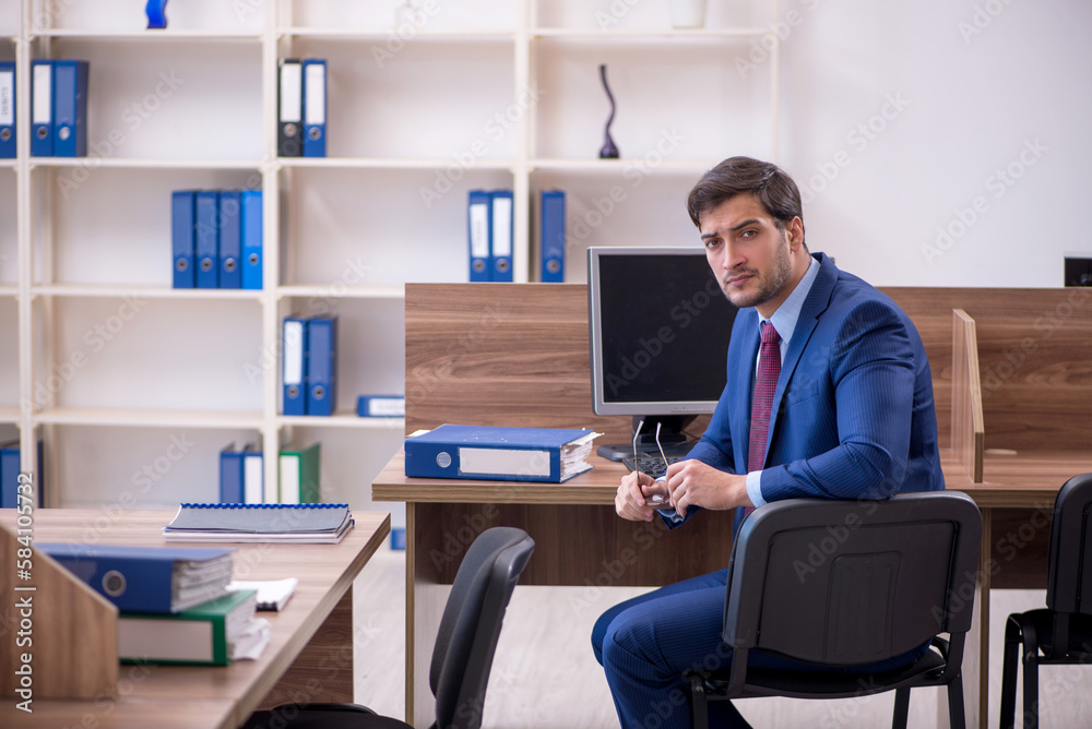 Young male employee working in the office Young male employee working in the office