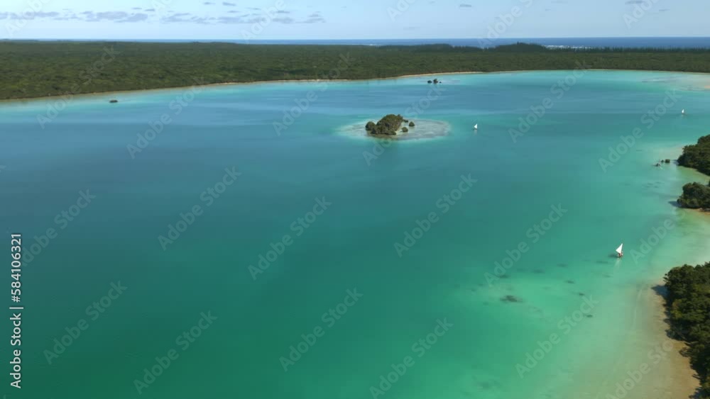 Aerial parallax over Upi Bay, Isle of Pines. Pirogues sailing tourists on bay. Aerial parallax over Upi Bay, Isle of Pines. Pirogues sailing tourists on bay.