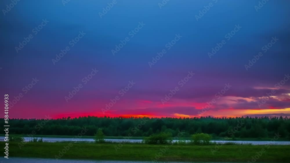 Green meadow and river under a pink cloudy sky at sunset. Timelapse shot. Green meadow and river under a pink cloudy sky at sunset. Timelapse shot.