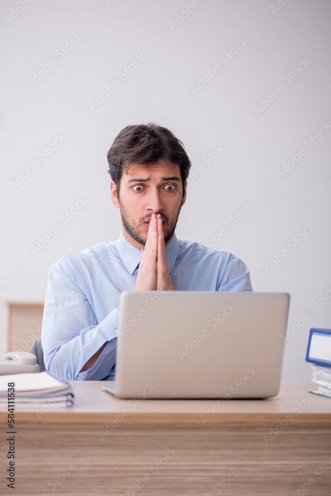 Young male employee sitting in the office Young male employee sitting in the office