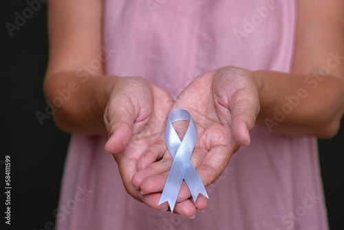 Close-up: A woman's hands shows pink ribbon as symbol of breast cancer. photo