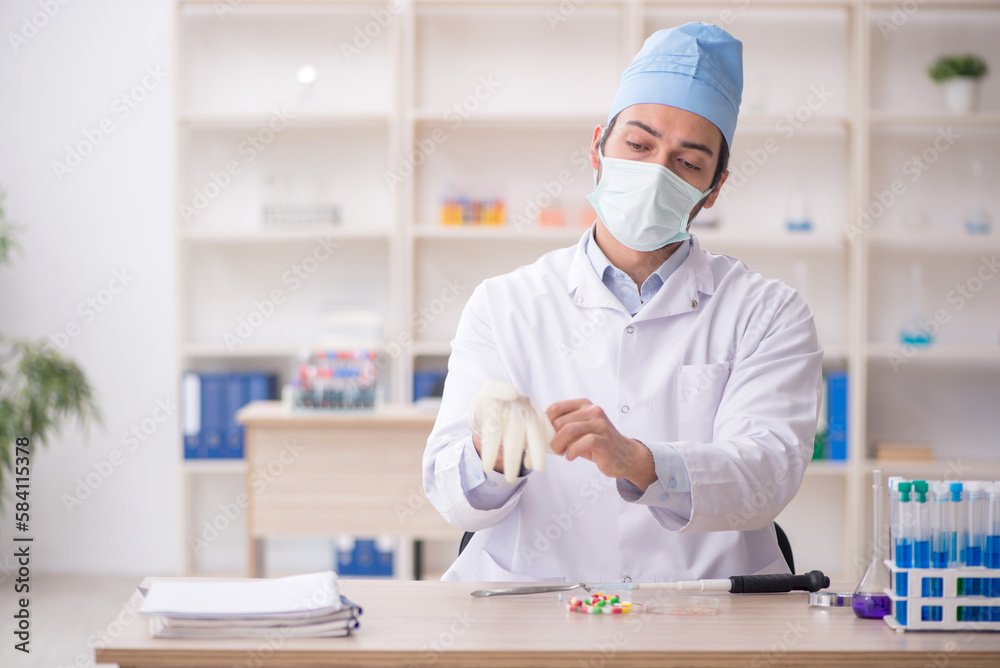Young male chemist working at the lab Young male chemist working at the lab