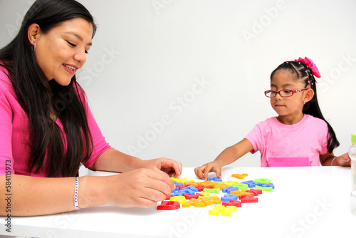 4-year-old Latina girl takes child therapy with the psychotherapist through games to treat her atuism and reflects emotions to learn about her cognitive abilities