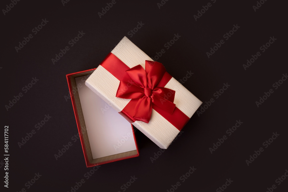 Open gift box with red bow on black background Open gift box with red bow on black background