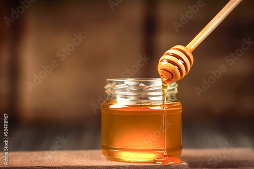 A wooden bowl with a honey dipper being dipped in honey, copyspace,  generative ai