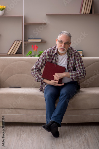 Old man reading book at home © Elnur