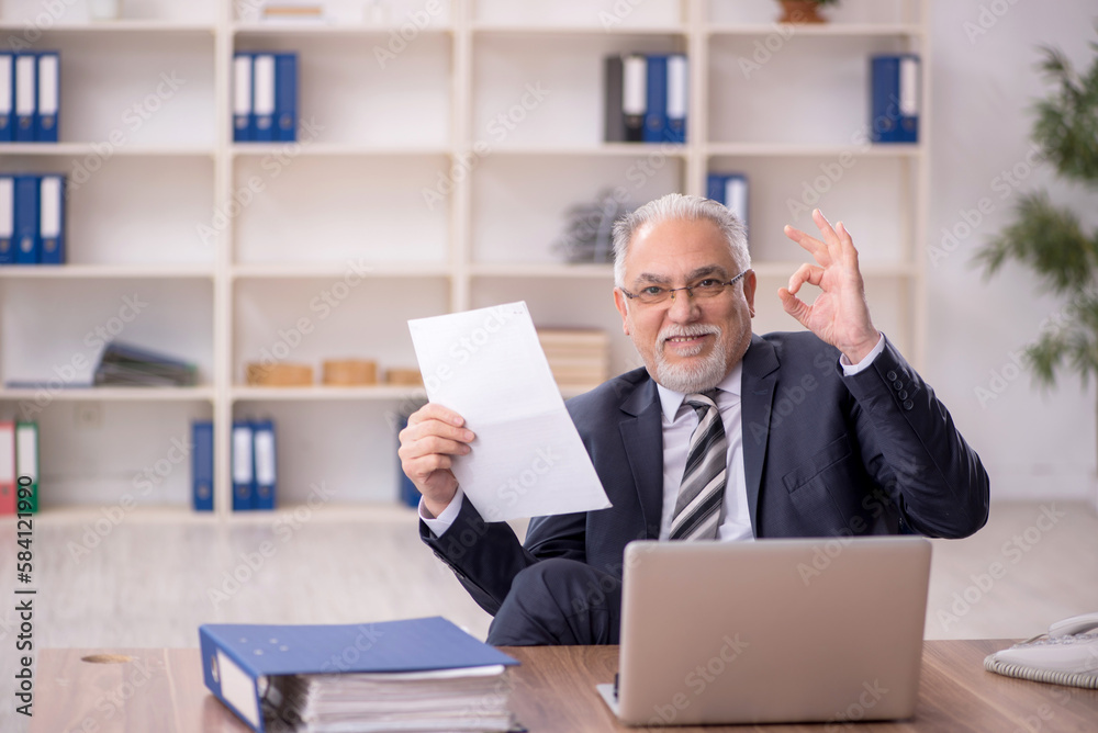 Old male employee working in the office Old male employee working in the office