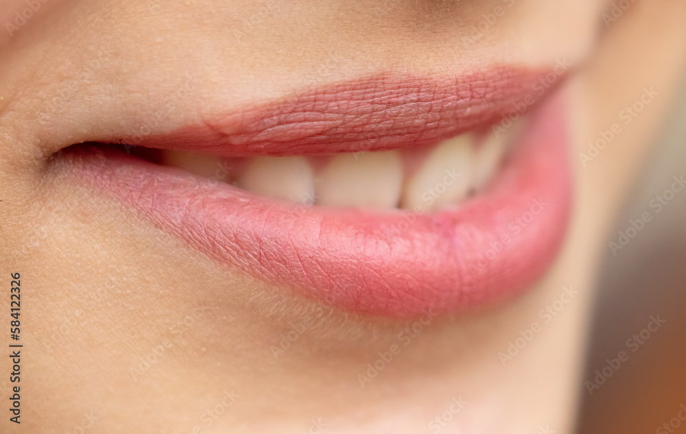 Fototapeta premium Lips of a young smiling girl as a background.