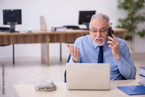 Old male employee working in the office