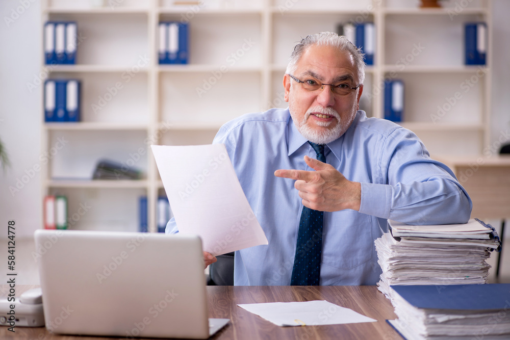 Old male employee working in the office Old male employee working in the office