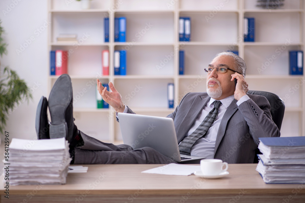 Old male employee working in the office Old male employee working in the office