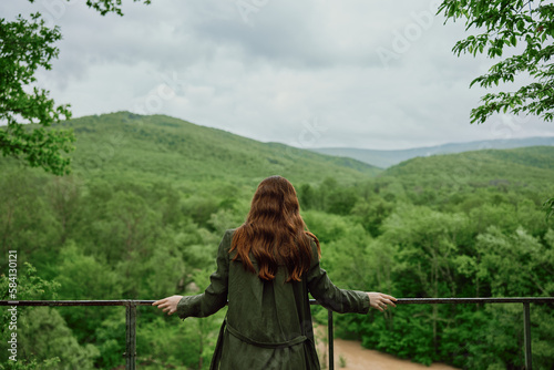 Wallpaper Mural a red-haired woman with beautiful, well-groomed, long hair stands with her back to the camera and enjoys the view of the forest Torontodigital.ca