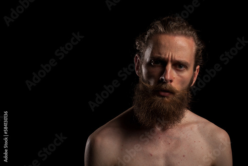 Portrait of cool bearded hipster on black background in studio photo. Expression and fashion