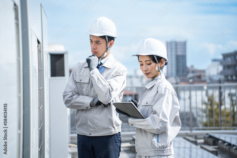 考える作業着を着た日本人男女 考える作業着を着た日本人男女