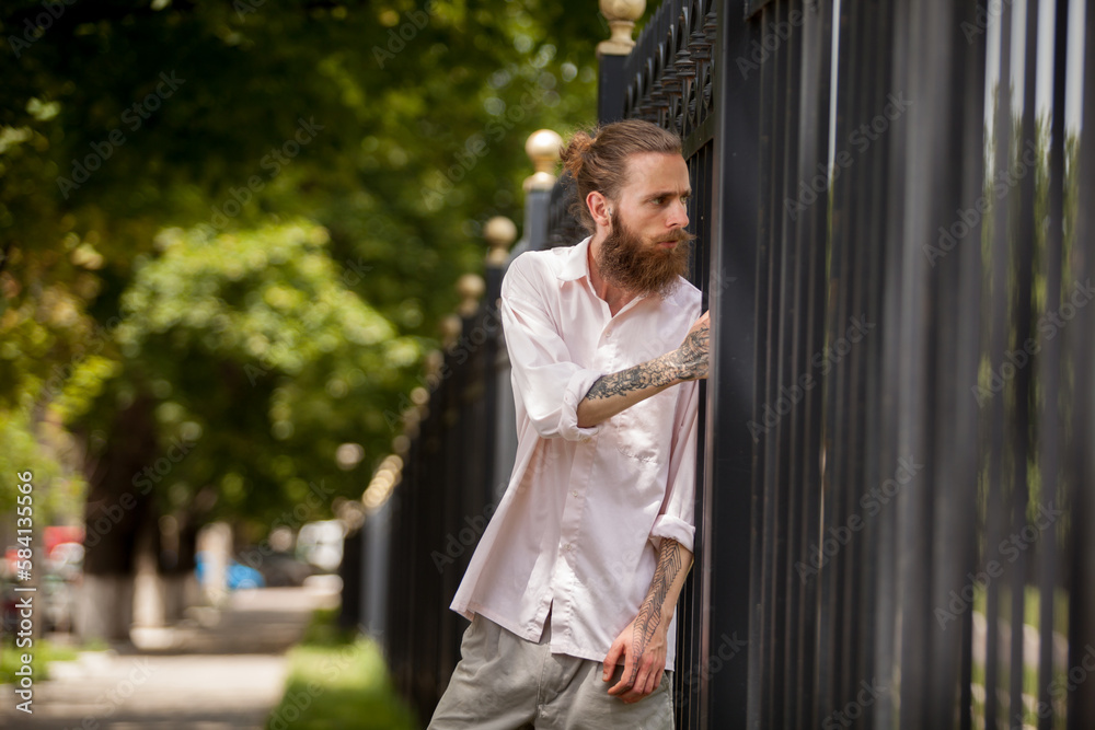 Hipster guy wih long beard posing outside in the city. Style and diversity