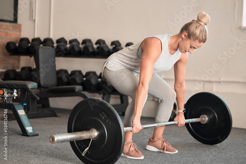 Fitness, weightlifting and a woman bodybuilder in the gym for a workout to build a strong muscular physique. Exercise, bodybuilding and a female weightlifter training her body in a wellness center