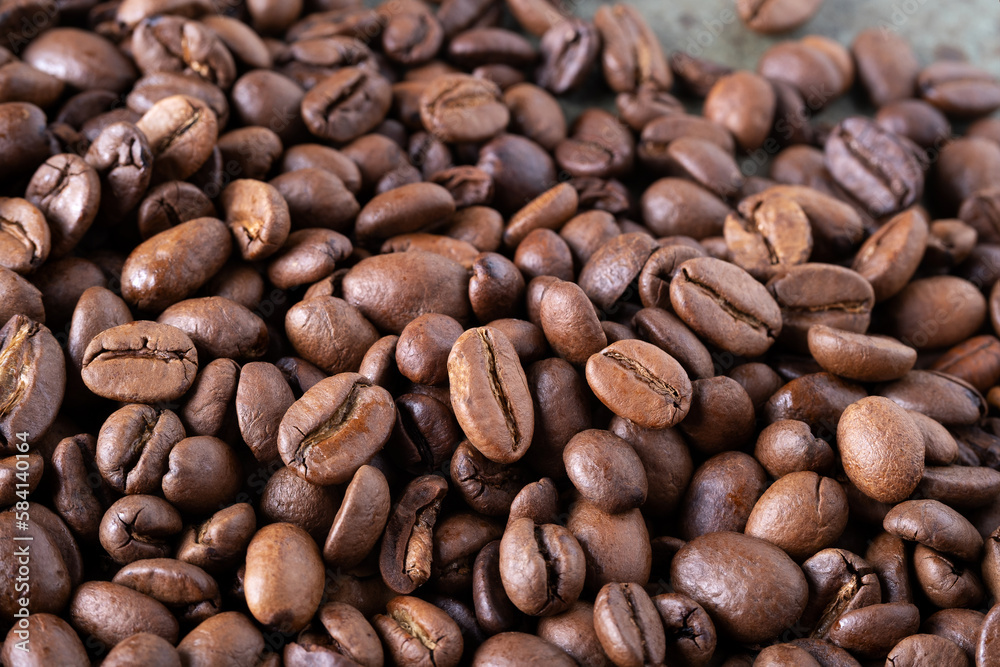 Close-up of roasted coffee beans on a green surface as a background. Selective focus. Close-up of roasted coffee beans on a green surface as a background. Selective focus.