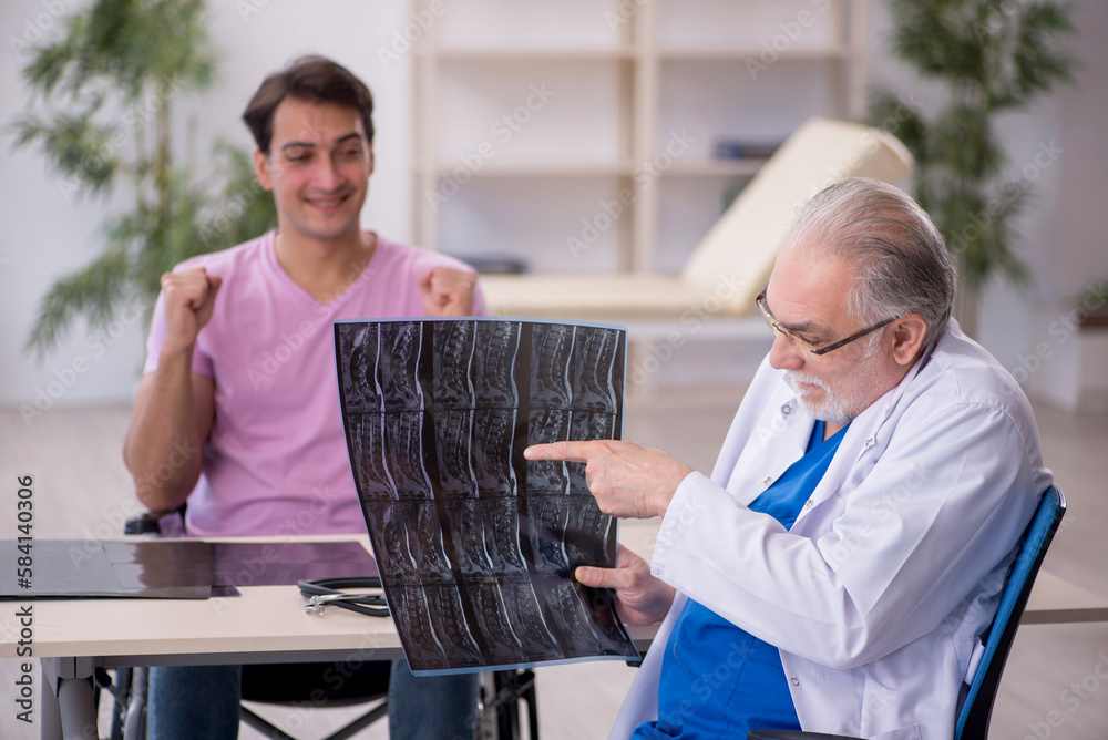 Obraz premium Young man in wheelchair visiting old doctor radiologist