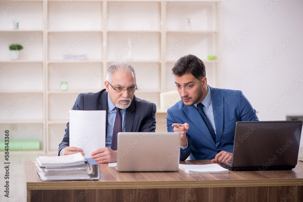 Two male employees working in the office Two male employees working in the office