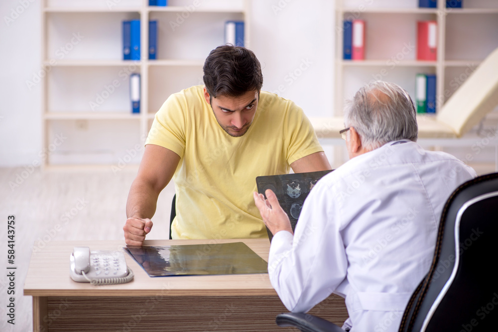Obraz premium Young male patient visiting old male doctor
