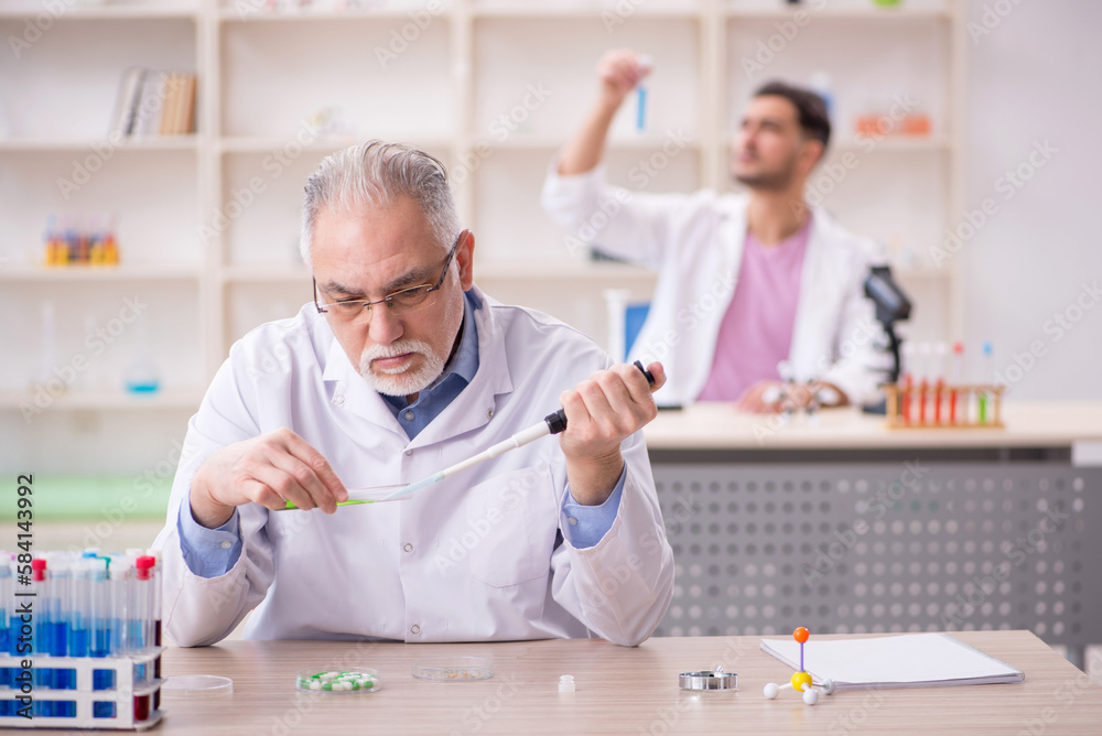Two male chemists working at the lab Two male chemists working at the lab