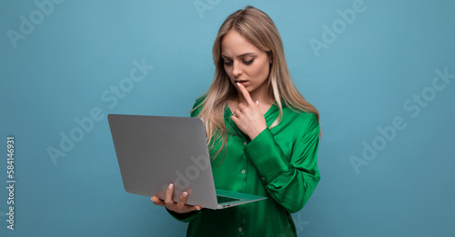 Photos thoughtful business lady freelancer working with a laptop in her hands on a blue