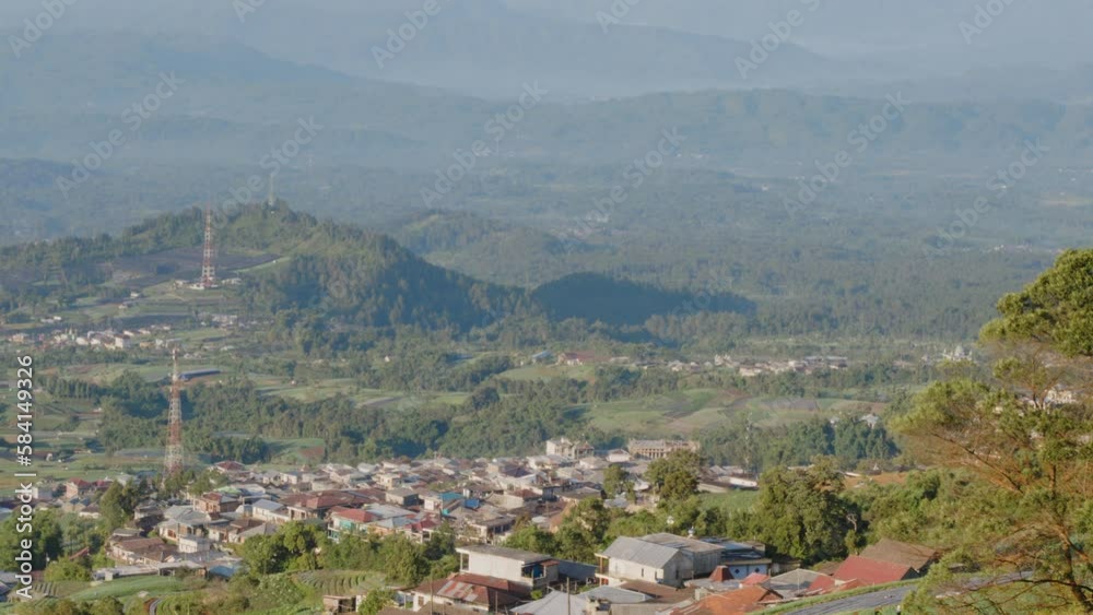 The view from a high place looks down on a low area in the form of a village in a valley between tropical mountains The view from a high place looks down on a low area in the form of a village in a valley between tropical mountains