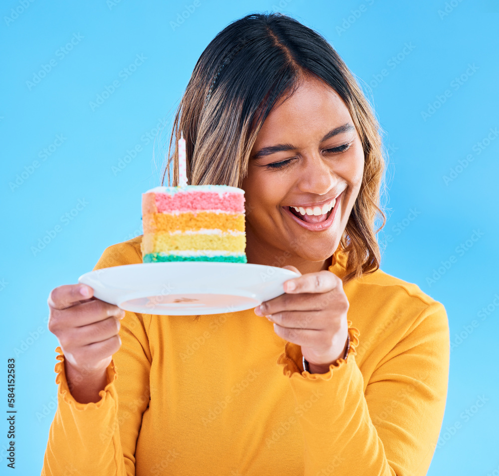 Woman, birthday cake and candle studio with a smile and excited to eat. Happy female person laughing on blue background with sweet rainbow color dessert for celebration and happiness on face Woman, birthday cake and candle studio with a smile and excited to eat. Happy female person laughing on blue background with sweet rainbow color dessert for celebration and happiness on face