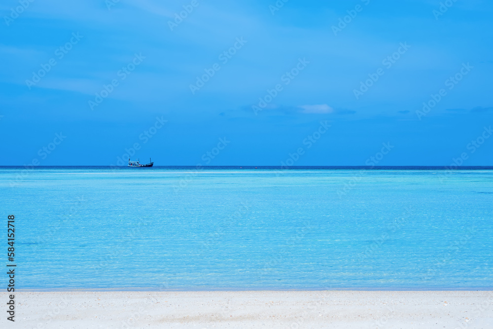 Mai Ngam Beach at Surin Island A small fishing boat floating in the middle of the sea as far as the eye can see. near white sand beach Island in the Andaman Sea, Kuraburi, Phang Nga, Thailand.