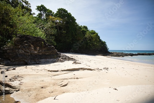 Fototapeta Naklejka Na Ścianę i Meble -  White sandy beach of El Nideo, Palawan in the Philippines with a rough rock and trees.