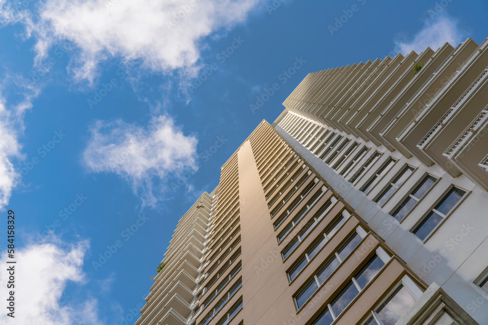 Modern multi-storey building in a low angle view at Miami, Florida. Hotel Apartment building exterior with balconies on both corners view from below under the sky. Modern multi-storey building in a low angle view at Miami, Florida. Hotel Apartment building exterior with balconies on both corners view from below under the sky.