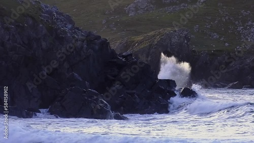 Golden hour shot of the waves crashing against the cliffs at Dalmore beach near Carloway. Filmed on the Isle of Lewis, part of the Outer Hebrides of Scotland. photo
