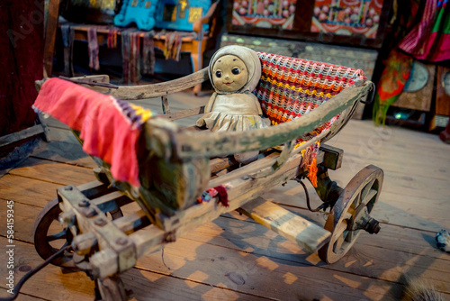 Fototapeta Naklejka Na Ścianę i Meble -  Creepy baby girl doll in a cradle on wheels