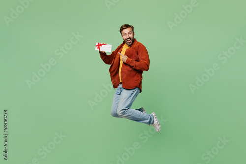 Full body elderly man 40s years old wear casual clothes red shirt t-shirt jump high hold gift certificate coupon voucher card for store isolated on plain pastel light green background studio portrait