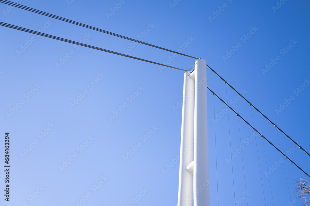 Wire ropes are connected to metal poles to create a secure perimeter in the sky background area Wire ropes are connected to metal poles to create a secure perimeter in the sky background area