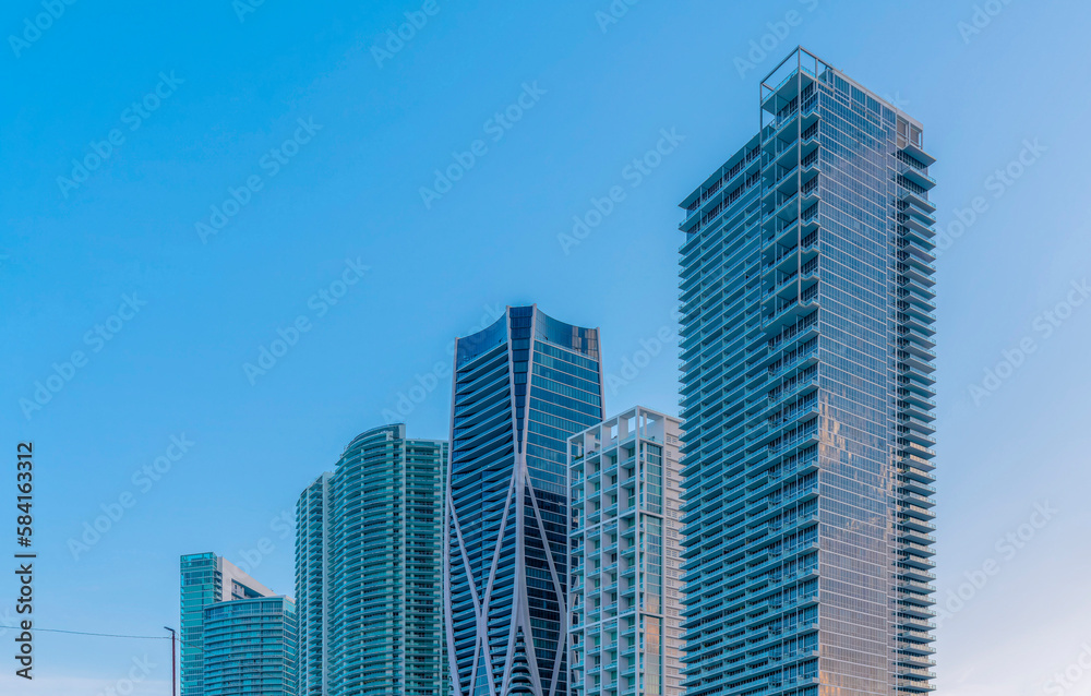 Miami, Florida cityscape against the clear sky in the background. Row of modern glass buildings with different architectural exterior.