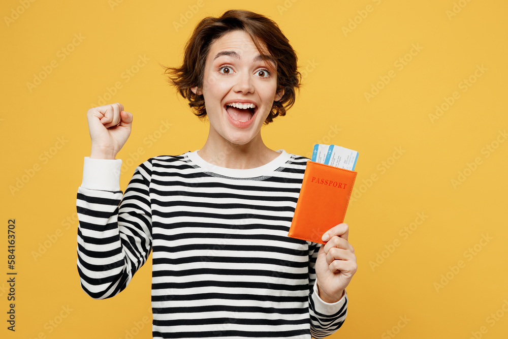 Traveler fun woman wear casual clothes hold passport ticket do winner gesture isolated on plain yellow color background. Tourist travel abroad in free spare time rest getaway. Air flight trip concept. Traveler fun woman wear casual clothes hold passport ticket do winner gesture isolated on plain yellow color background. Tourist travel abroad in free spare time rest getaway. Air flight trip concept.