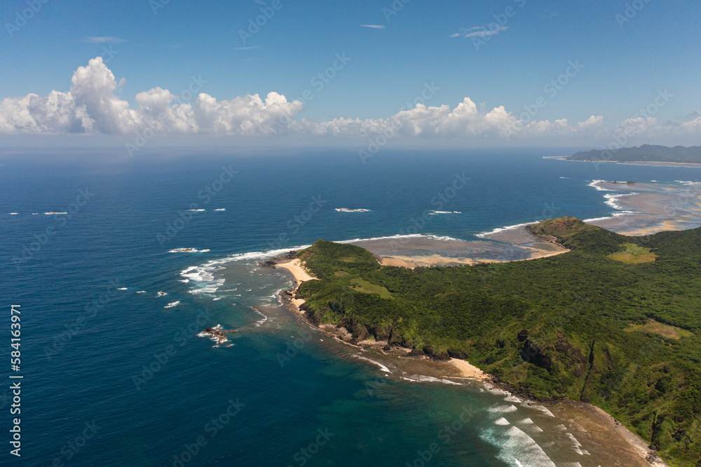 Aerial drone of tropical island with jungle and blue sea. Cape Engano. Palaui Island. Santa Ana Philippines.
