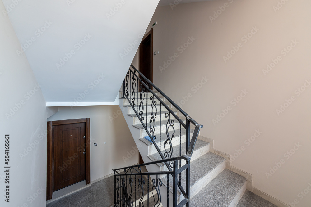 Obraz premium Modern stair case between floors. Stairs with metallic rail in modern building