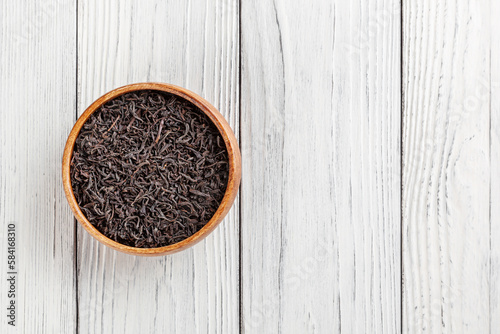 Obraz na płótnie Dry black tea in wooden bowl on white wooden background with copy space w salonie