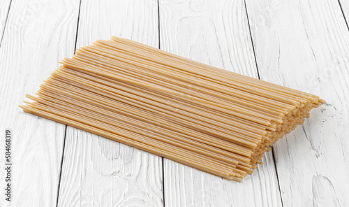 Obraz na płótnie Uncooked spaghetti pasta on white wooden background w salonie