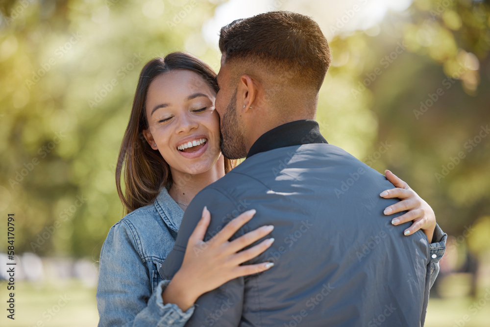 Couple, outdoor and kiss on cheek with a smile for love, care and happiness together in summer. Young man and woman at nature park for affection or hug on happy and romantic date or vacation to relax