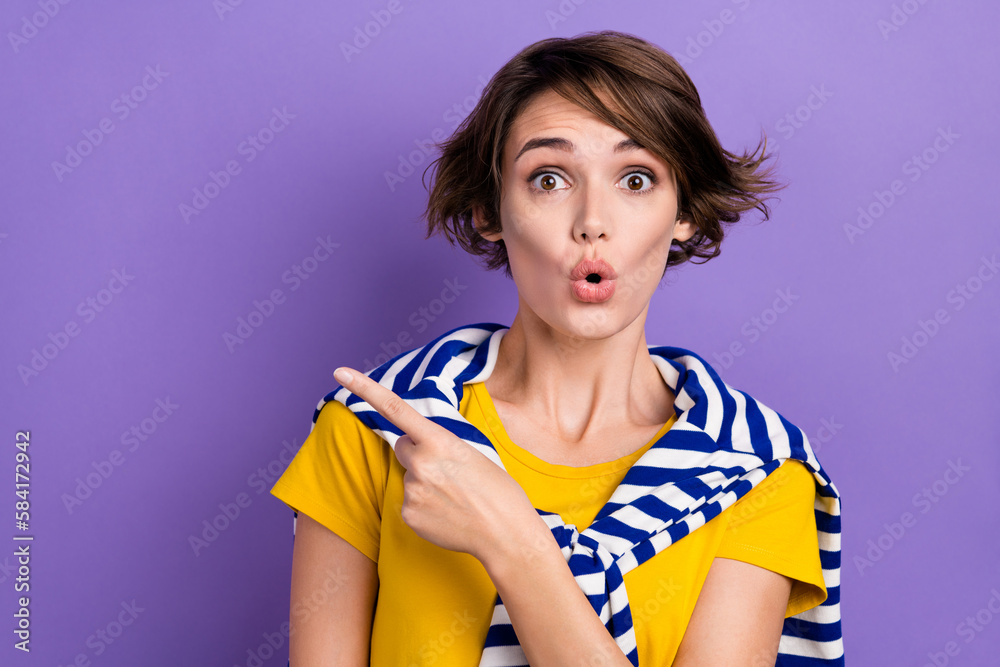 Photo of positive shocked woman wear tied sweater pointing finger empty space isolated purple color background Photo of positive shocked woman wear tied sweater pointing finger empty space isolated purple color background