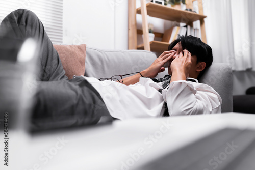 Close up of businessman stressed lying on the sofa