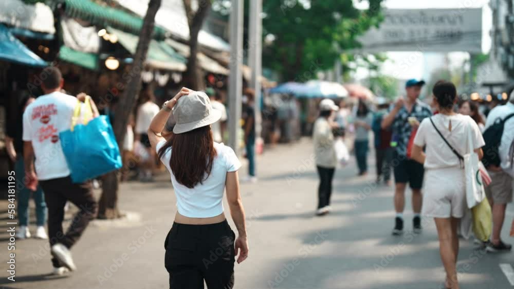 woman traveler visiting in Bangkok, Tourist with hat sightseeing in Chatuchak Weekend Market, landmark and popular attractions in Bangkok, Thailand. Travel in Southeast Asia concept woman traveler visiting in Bangkok, Tourist with hat sightseeing in Chatuchak Weekend Market, landmark and popular attractions in Bangkok, Thailand. Travel in Southeast Asia concept