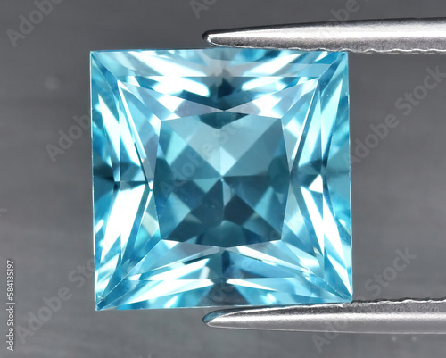 Natural blue topaz gemstone on gray background
