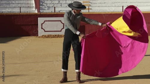 Bullfighter dressed in traditional matador costume from southern spain practicing with the cape in a bullring photo