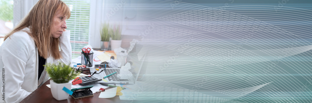 Overworked businesswoman sitting at a messy desk; panoramic banner Overworked businesswoman sitting at a messy desk; panoramic banner