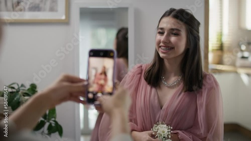 Mother taking and checking picture of her daughter in dress before prom party. Shot with RED helium camera in 8K.     